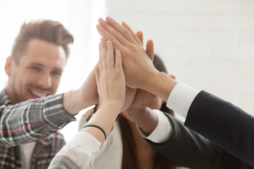 Close up of colleagues giving high five celebrating successful s